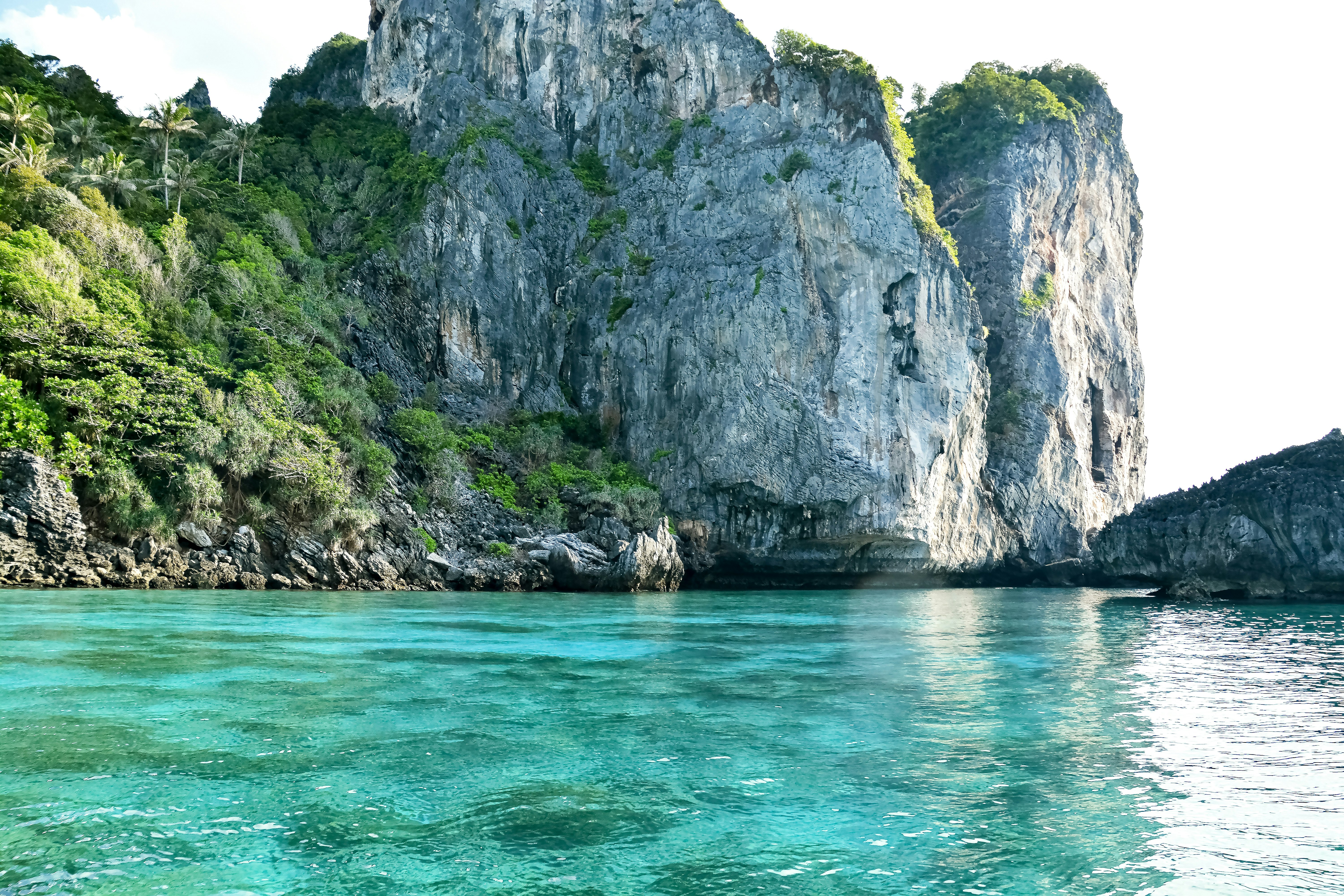 body of water near gray rock formation during daytime